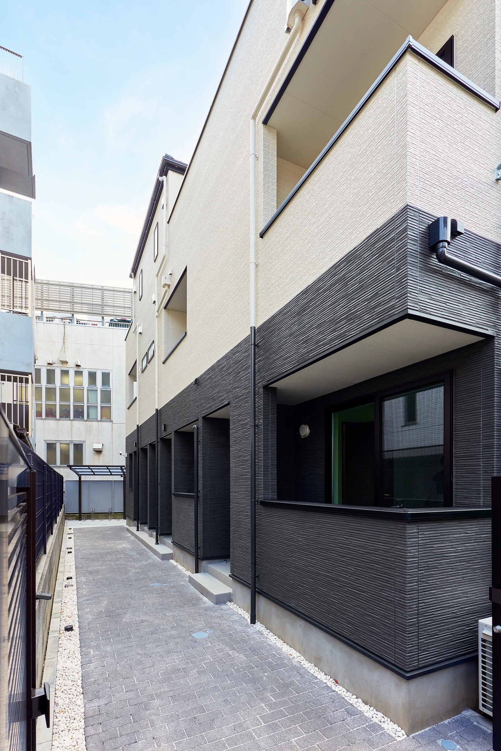 玄関が並ぶ建物とアプローチ
